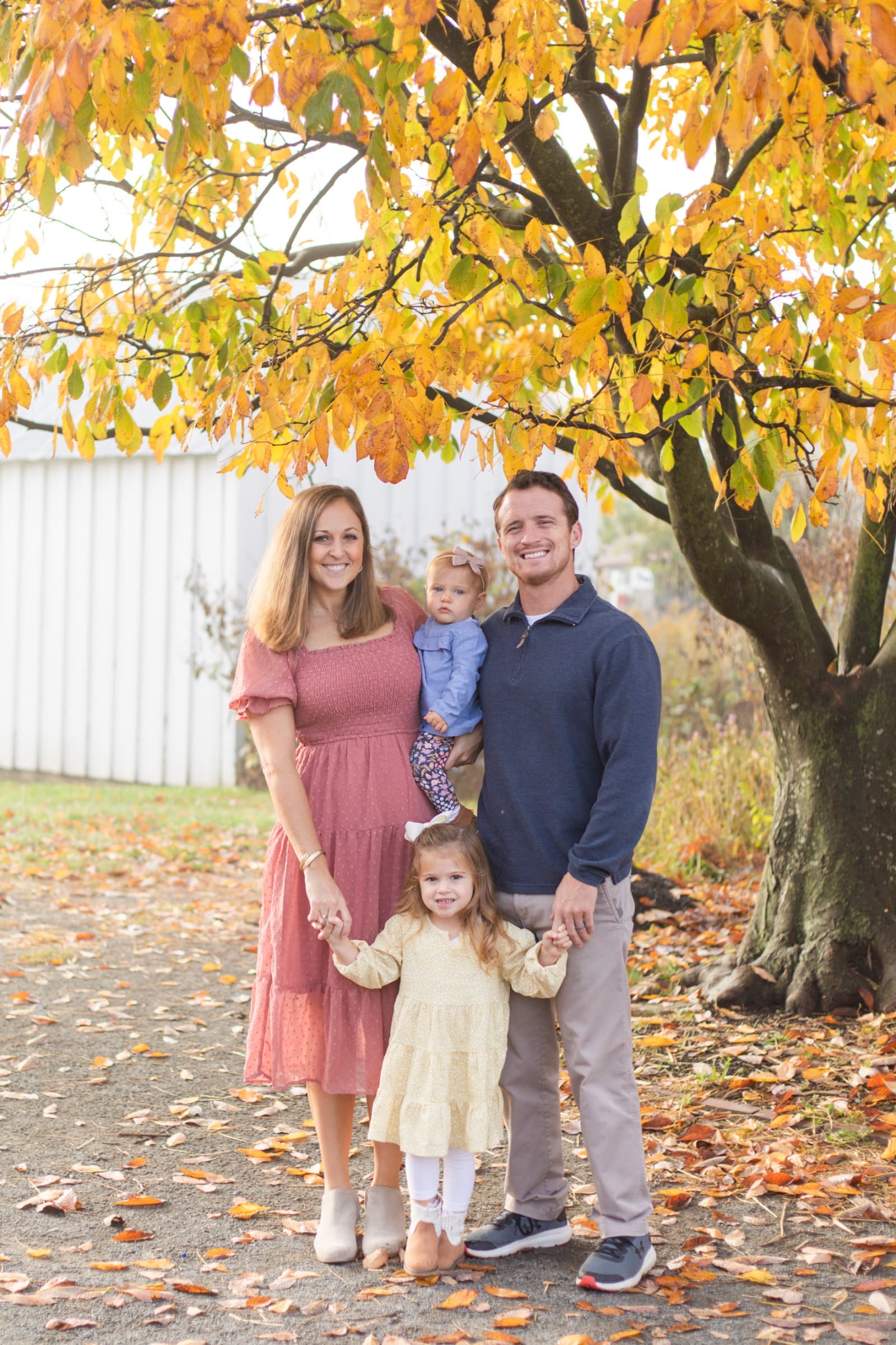 Family of four under a golden fall tree
