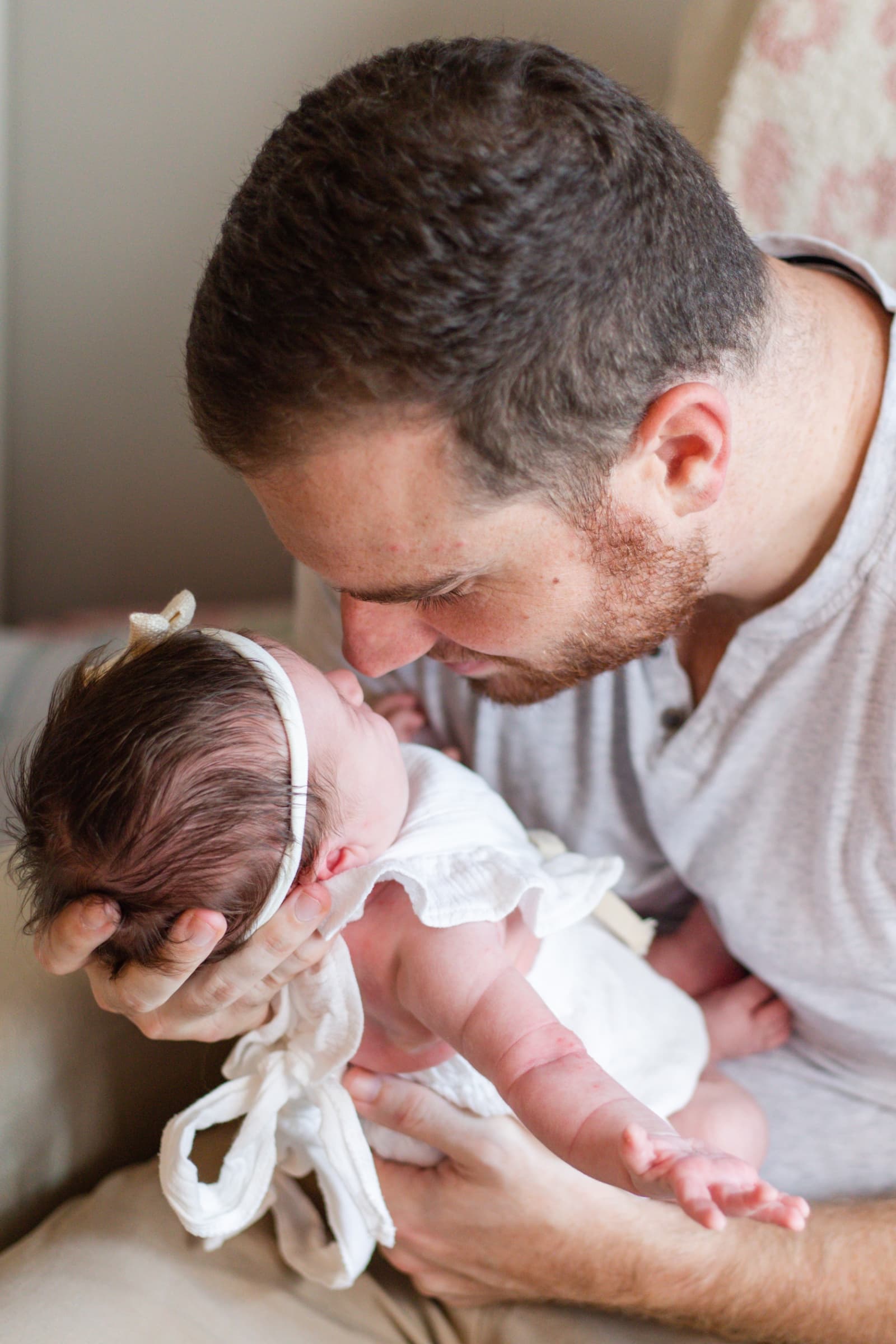 Father nuzzling his newborn daughter
