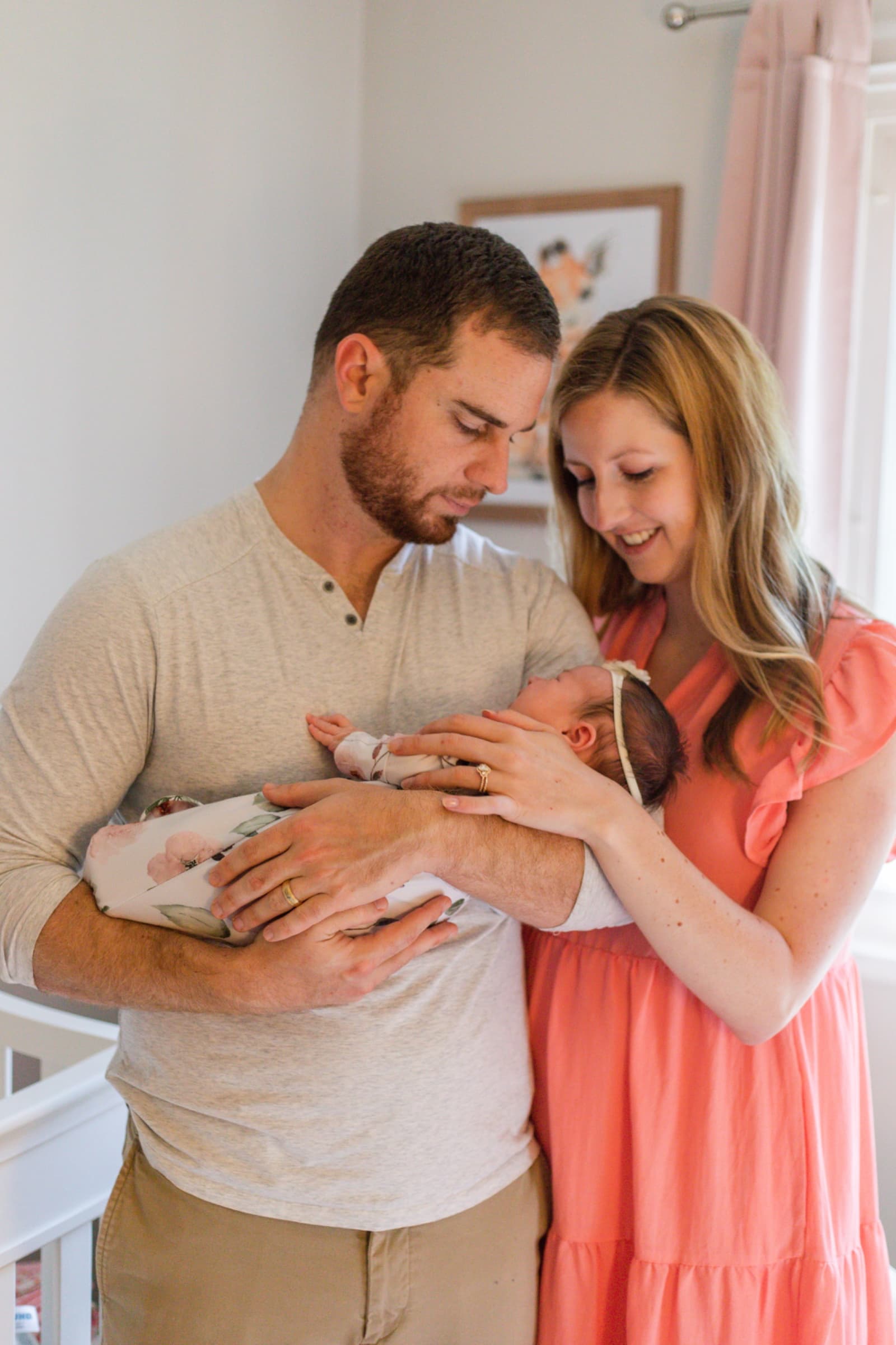 Parents holding their swaddled newborn together