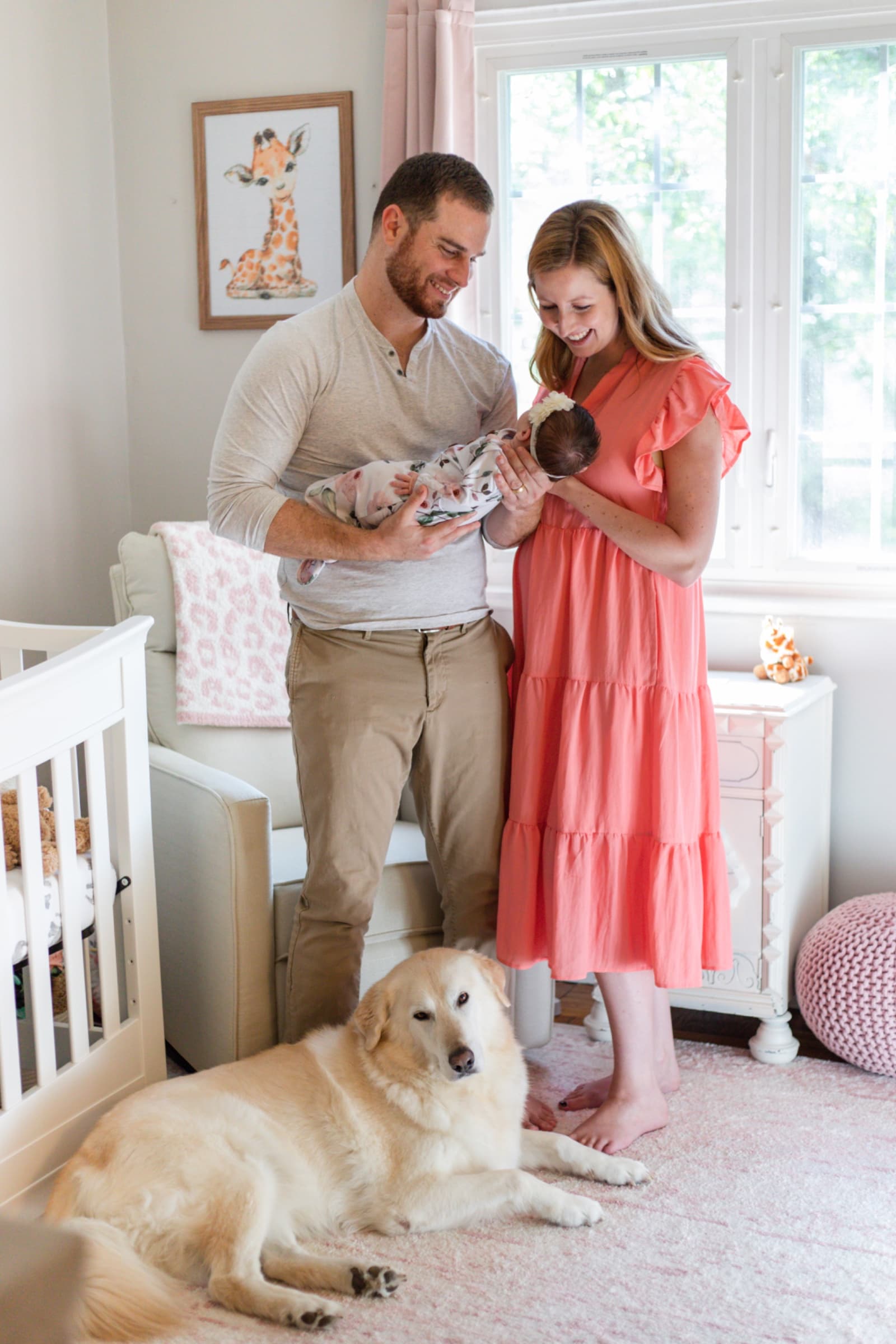 Family with their golden retriever in the nursery